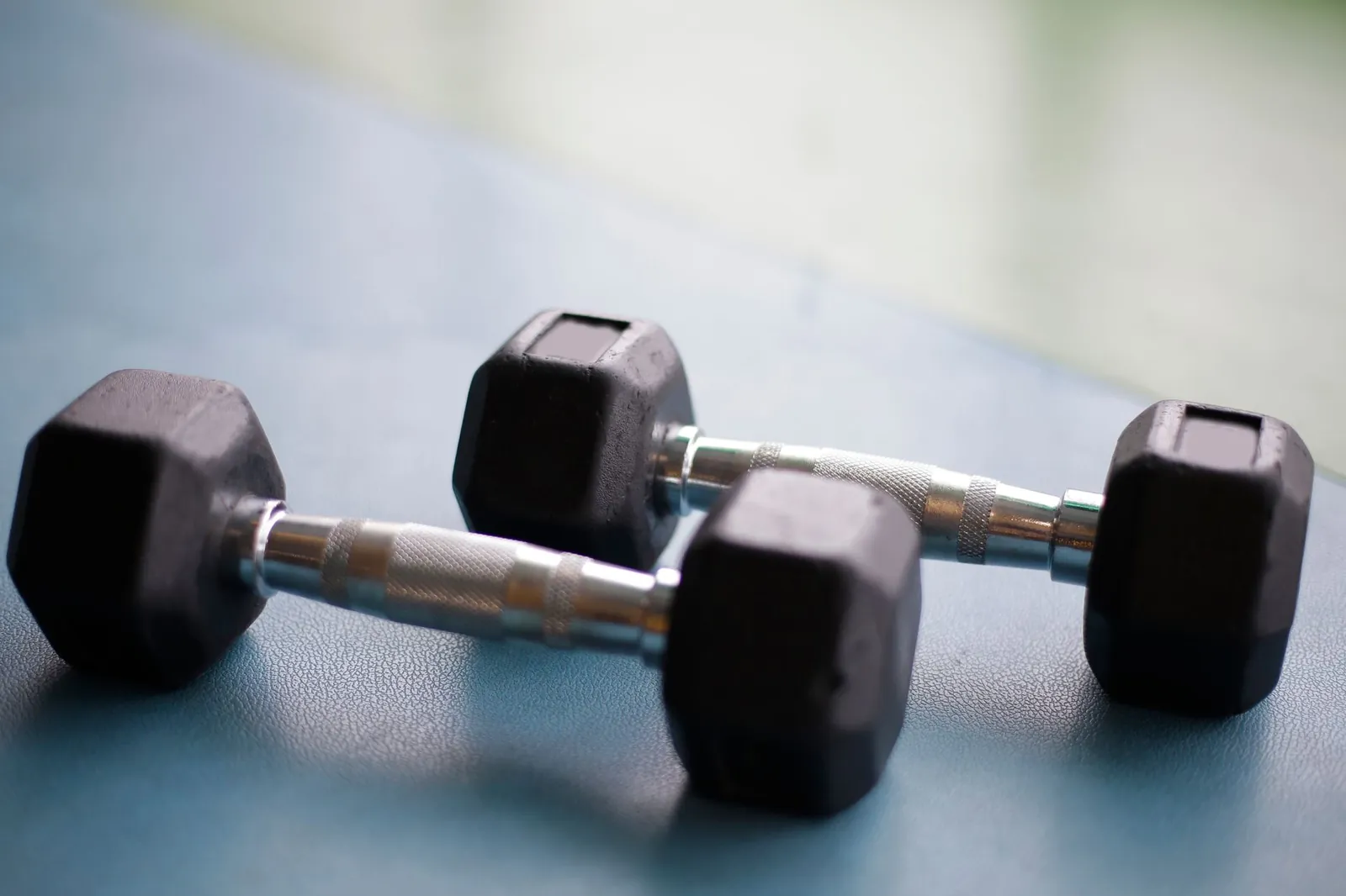 Athlete pressing dumbbells on a flat bench during an upper body strength session