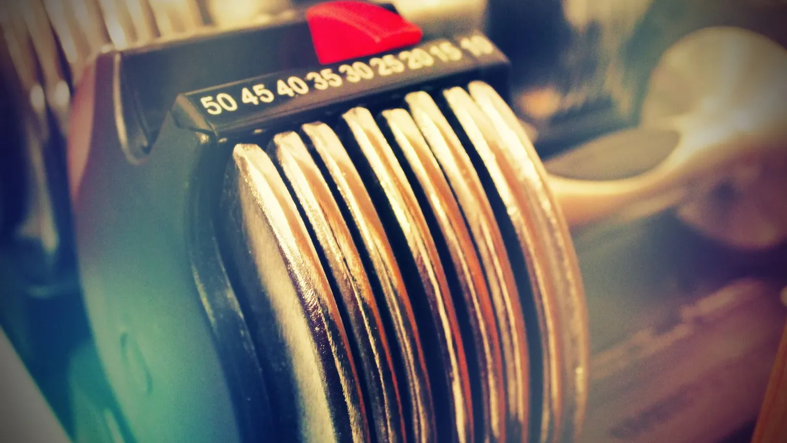 Dial-based adjustable dumbbell showing weight selector and increment markings at the 25-pound setting