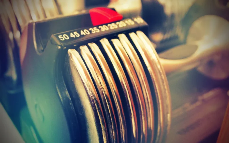 Dial-based adjustable dumbbell showing weight selector and increment markings at the 25-pound setting