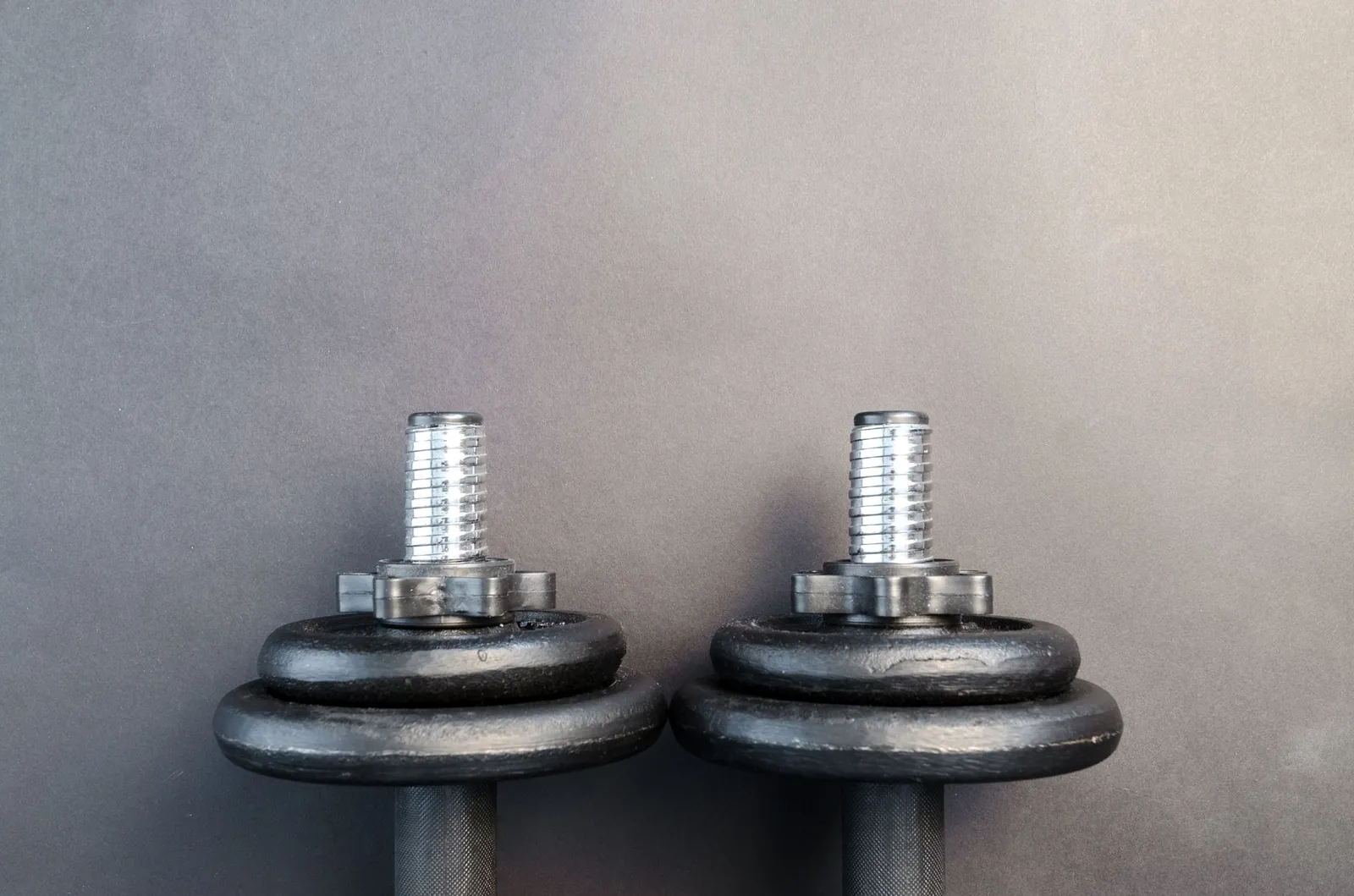 Bowflex SelectTech 552 and PowerBlocks Pro side by side on a home gym rubber floor mat