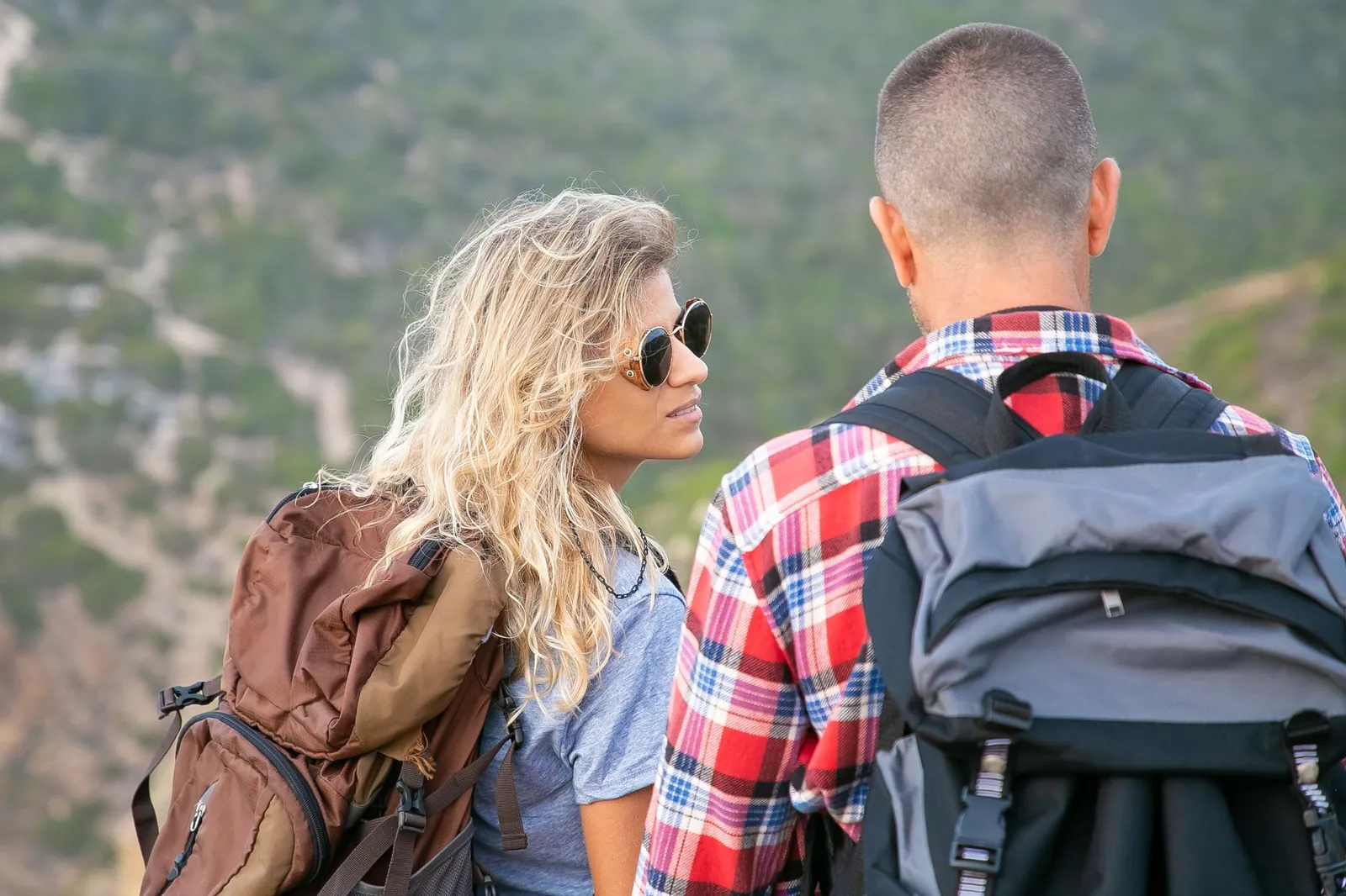 Five popular beginner backpacking packs arranged side by side showing size and color differences