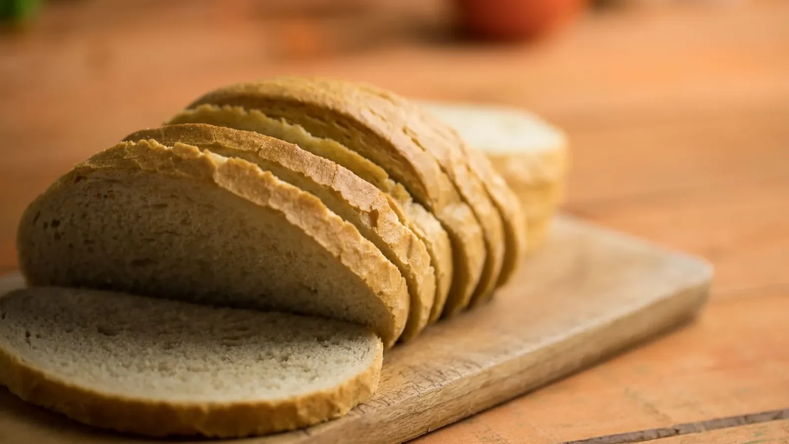 Oats, brown rice, sweet potatoes, bananas, and whole grain bread arranged by glycemic speed on a wooden surface