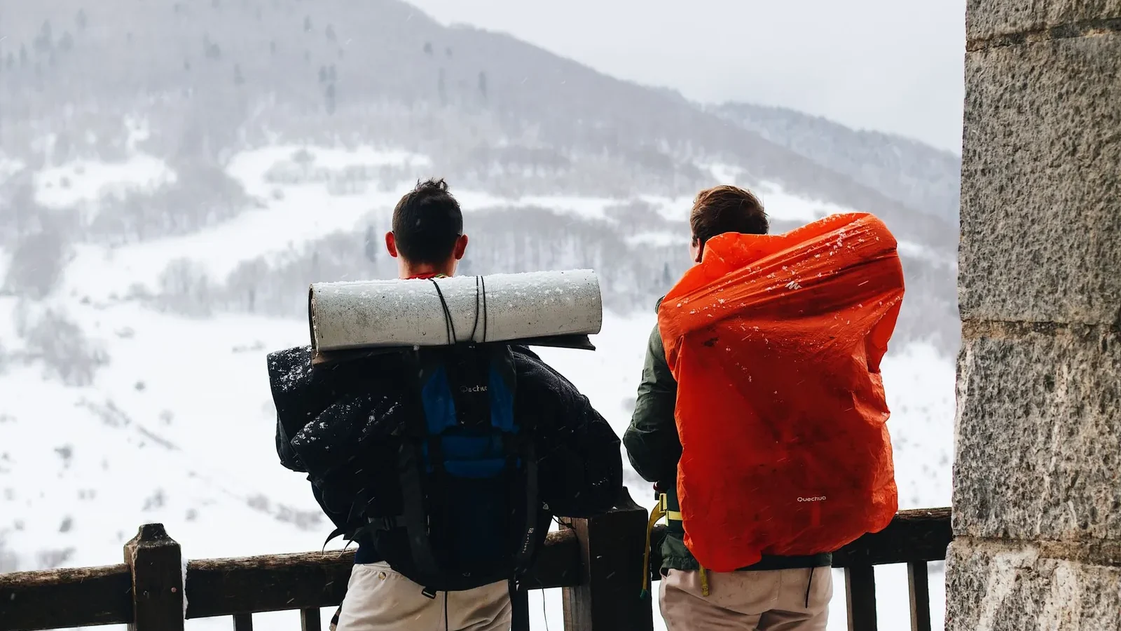Hiker wearing broken-in mid-cut hiking boots and a fitted 25L daypack on a rocky forest trail