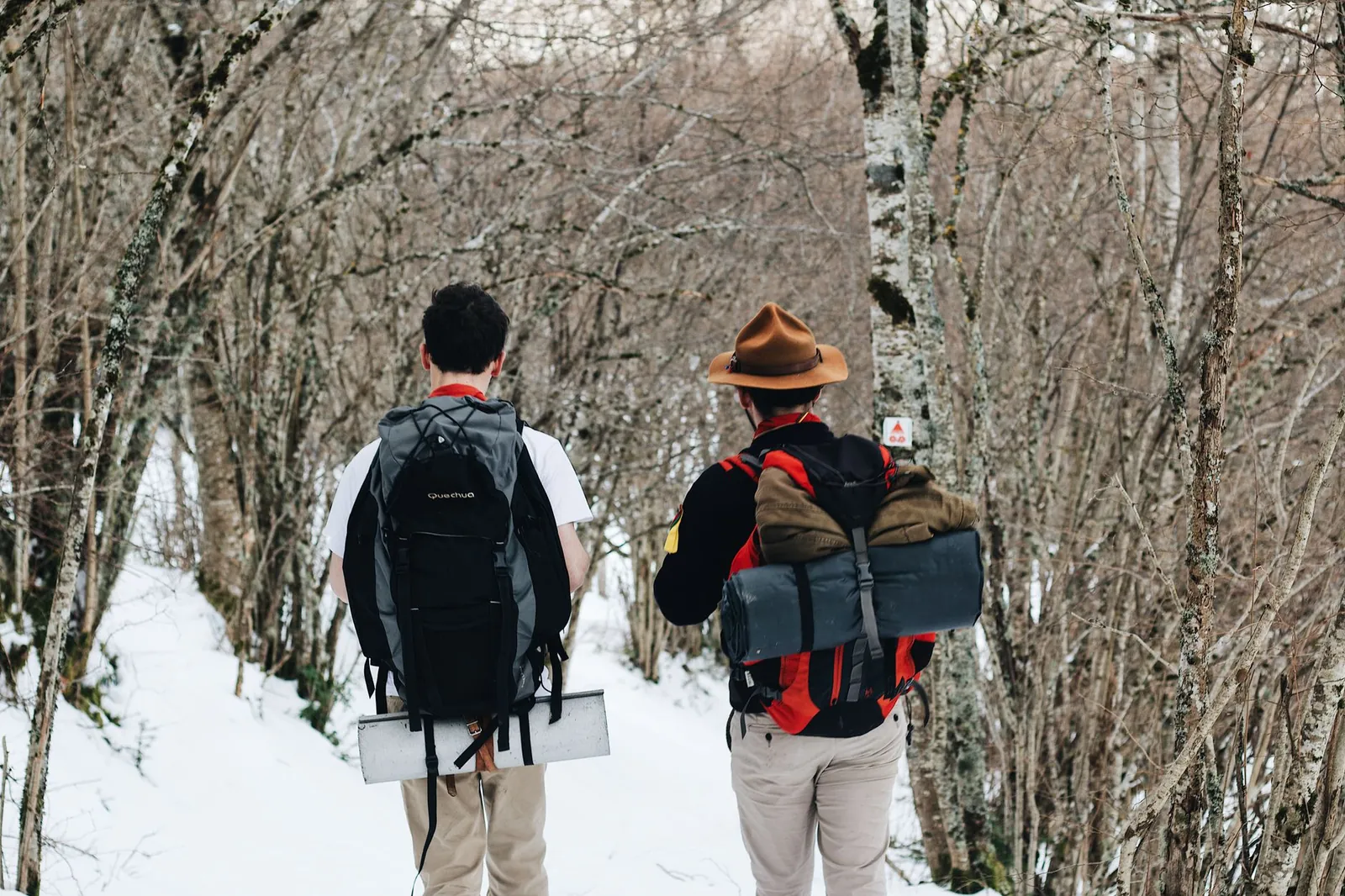 Daypack exterior pockets organized with a water bottle, folded paper map, headlamp, and whistle ready for a day hike