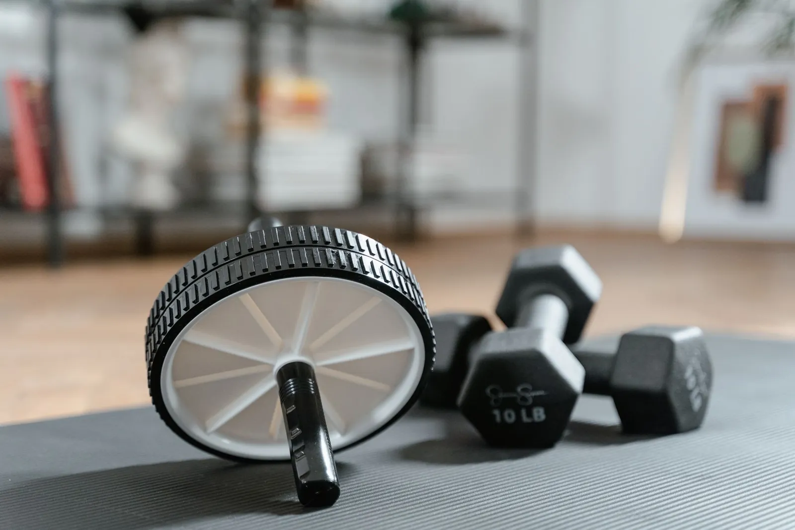 Adjustable dumbbells with pin-selector system on a home gym floor, set to 25 lbs per hand