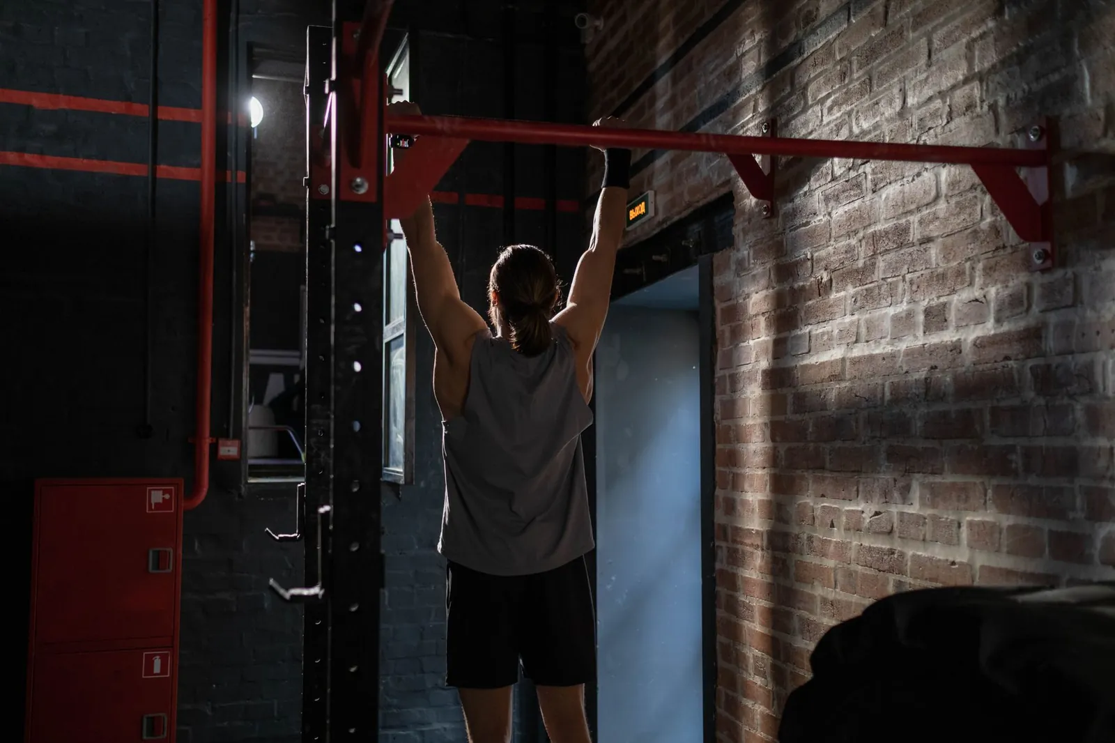 Four types of home pull up bars side by side: doorway bar, wall-mounted bar, power tower, and ceiling-mounted bar in a garage gym