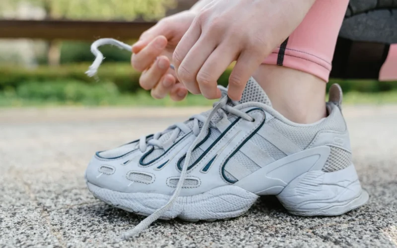 Cross-section of a stability running shoe showing the firm medial post foam wedge on the inner midsole, designed to control overpronation in flat feet