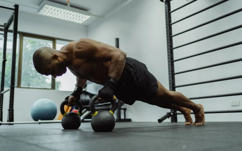 Person performing a push-up with proper form, body straight from head to heels on a wooden floor