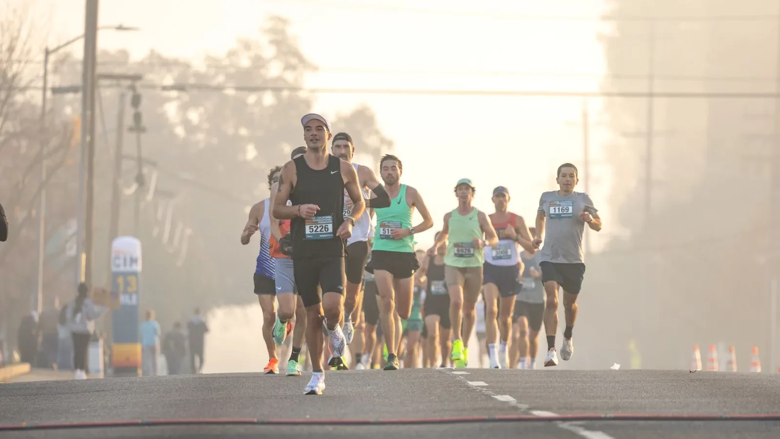 Runner on an open road at dawn maintaining upright posture and midfoot strike during a long training run
