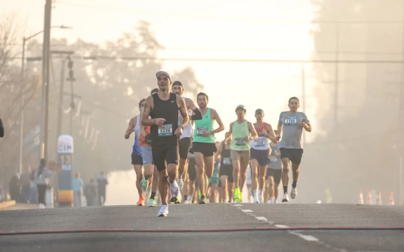 Runner on an open road at dawn maintaining upright posture and midfoot strike during a long training run
