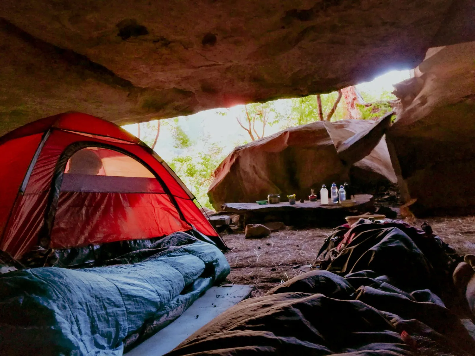 Sleeping bags sorted by temperature rating on a tent floor, showing down and synthetic options side by side