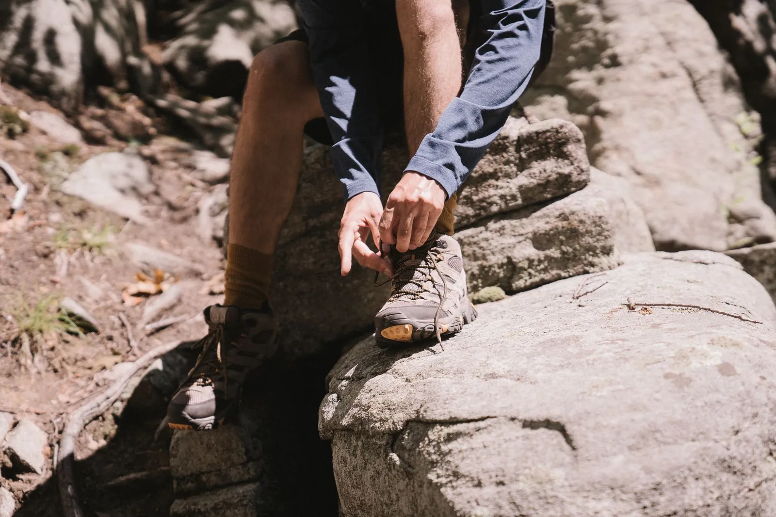 Four types of hiking footwear displayed side by side: lightweight hiking shoe, mid-cut hiking boot, high-cut backpacking boot, and insulated mountaineering boot