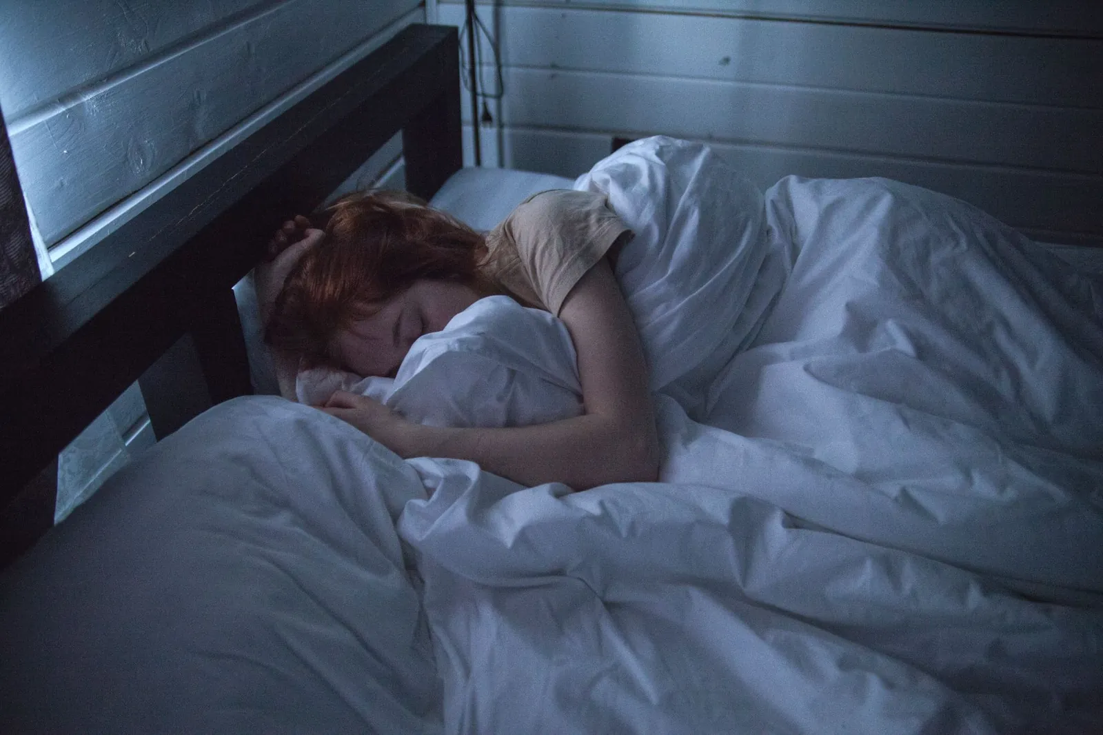 Athlete sleeping in bed during afternoon recovery nap
