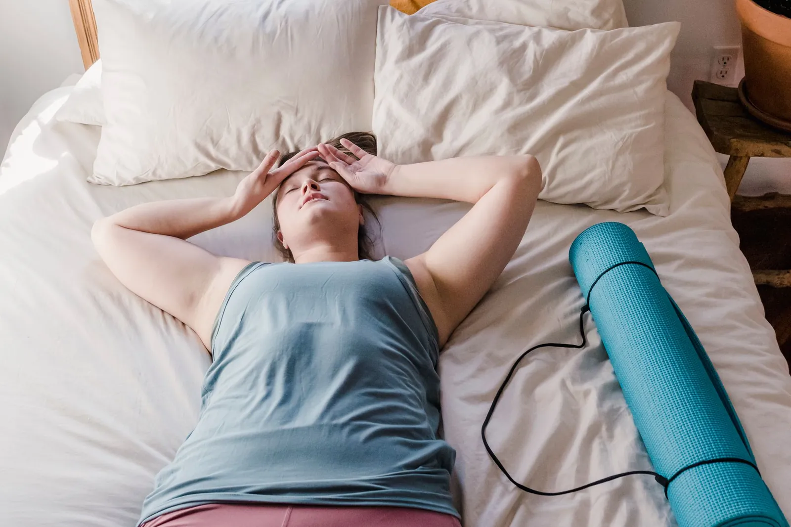 Person doing light stretching on yoga mat after workout