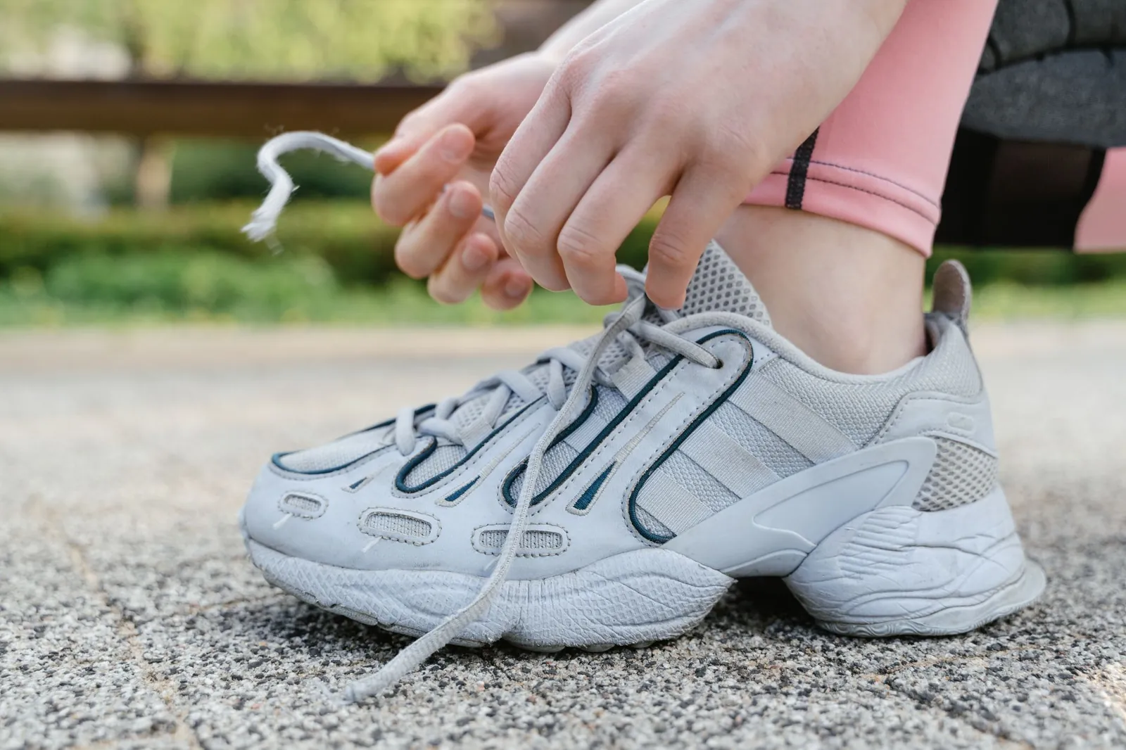 Runner's foot in a shoe with adaptive lacing zones highlighted, showing independent heel and forefoot tension adjustment