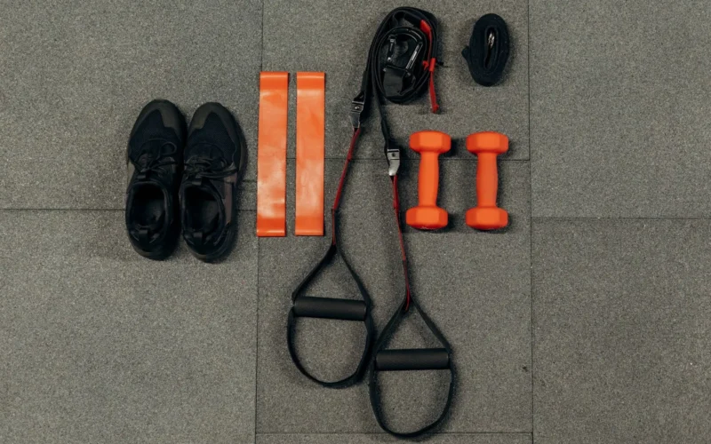 Side-by-side demonstration of a dumbbell bicep curl versus a resistance band curl, showing the difference in resistance curve at the top and bottom of each movement