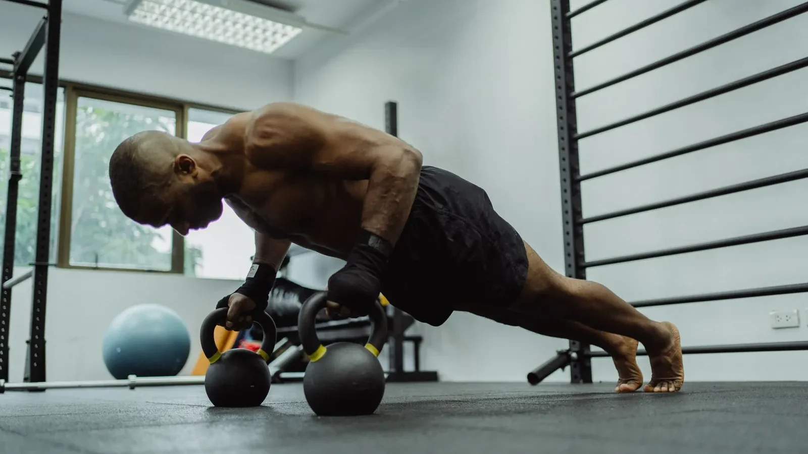 Athlete performing a barbell bench press in a gym rack during upper body strength day