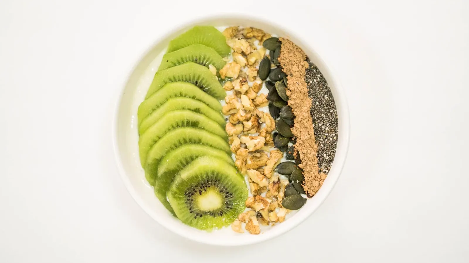 Woman eating a bowl of oatmeal with berries and yogurt before a morning run